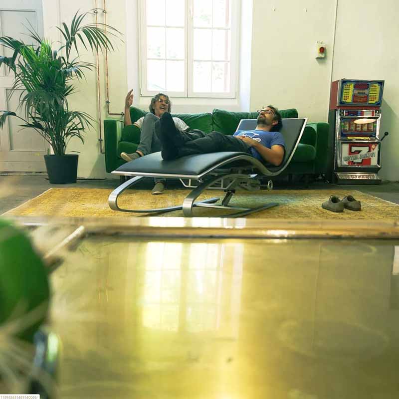 Raum für Entspannung im Coworking Space mit einem Mann liegend auf einem gemütlichen Sessel
